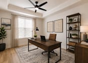 Thumbnail 13 of 50 - A room with a desk, chair, and a plant.
