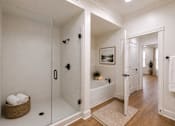 Thumbnail 15 of 50 - A bathroom with a glass shower door and a white bathtub.
