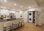 Thumbnail 16 of 50 - A modern kitchen with a black countertop and white cabinets.