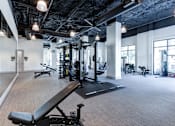 Thumbnail 19 of 47 - A gym with a variety of equipment including a weight bench.