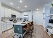 Thumbnail 4 of 47 - A kitchen with white cabinets and a green island.