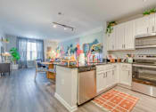 Thumbnail 2 of 20 - kitchen with white cabinets and stainless steel appliances at the bradley braddock road station apartments