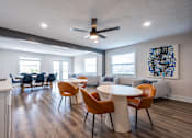 Thumbnail 16 of 25 - A room with a white ceiling fan and a white table with chairs.