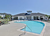 Thumbnail 27 of 49 - A large swimming pool in front of a building with a white facade and a black roof.