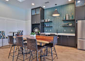 Thumbnail 5 of 49 - A kitchen with a table and chairs in the foreground and a refrigerator in the background.