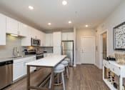 Thumbnail 14 of 49 - A modern kitchen with a dining table and chairs.