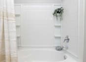 Thumbnail 23 of 49 - A white bathroom with a white tub and a white shower.