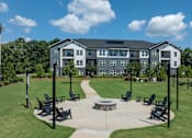 Thumbnail 39 of 49 - A large building with a grassy area in front and a clear blue sky above.