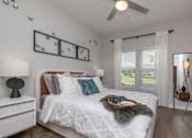Thumbnail 21 of 49 - A bedroom with a large bed and a ceiling fan.