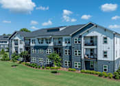 Thumbnail 47 of 49 - A large apartment complex with multiple buildings and green lawns.