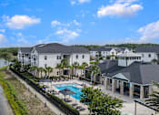 Thumbnail 43 of 45 - A large white building with a pool in front of it.