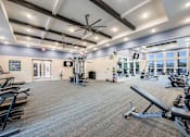 Thumbnail 11 of 45 - A gym with a variety of equipment including treadmills, weights, and exercise machines.