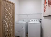 Thumbnail 27 of 45 - A washing machine and dryer in a small room.