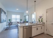 Thumbnail 9 of 18 - a kitchen with an island and a living room in the background