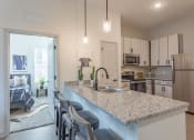 Thumbnail 8 of 18 - a kitchen with white cabinets and a granite counter top