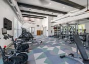 Thumbnail 13 of 37 - a spacious fitness center with cardio machines and weights
