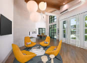 Thumbnail 5 of 37 - a living room with yellow chairs and a large screen tv