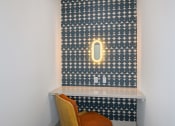 Thumbnail 9 of 37 - a small desk with a chair in front of a wall with a patterned wallpaper and a