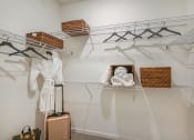 Thumbnail 24 of 37 - a walk in closet with a white robe and wicker baskets