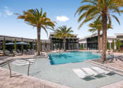 Thumbnail 25 of 37 - a swimming pool with palm trees and lounge chairs