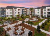 Thumbnail 34 of 37 - an aerial view of an outdoor dining area with a firepit in front of an apartment complex