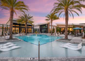 Thumbnail 27 of 37 - a large swimming pool with palm trees in front of a building