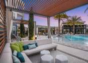 Thumbnail 30 of 37 - a patio with a couch and chairs and a pool in the background
