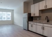 Thumbnail 4 of 19 - an empty kitchen with a refrigerator and cabinets