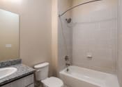 Thumbnail 10 of 19 - a bathroom with a white tub and a toilet and a sink