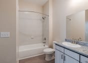 Thumbnail 11 of 19 - a bathroom with a shower toilet and sink and a mirror