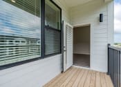 Thumbnail 14 of 19 - the entrance to a house with a large window and a wooden deck