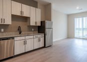 Thumbnail 7 of 19 - a kitchen with a stainless steel refrigerator and cabinets