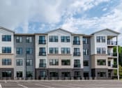 Thumbnail 16 of 19 - a row of apartment buildings in a parking lot