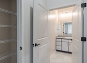 Thumbnail 9 of 19 - a bathroom with a white door and a sink and a mirror
