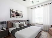 Thumbnail 9 of 33 - A bedroom with a large bed and a painting on the wall.