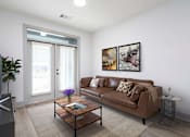 Thumbnail 8 of 33 - A living room with a brown couch, a coffee table, and a flat screen TV.