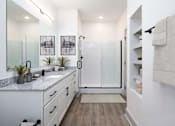 Thumbnail 10 of 33 - A modern bathroom with a walk-in shower and double sinks.