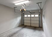 Thumbnail 44 of 59 - A garage with a white wall and a grey floor.