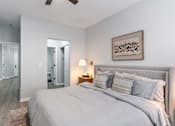 Thumbnail 14 of 59 - A bedroom with a large bed and a ceiling fan.