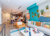 Thumbnail 4 of 20 - a living room with a blue accent wall and a gray couch