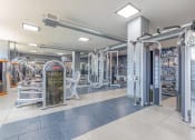Thumbnail 14 of 20 - a spacious fitness center with cardio machines and weights