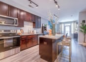 Thumbnail 2 of 20 - a kitchen with dark wood cabinets and stainless steel appliances