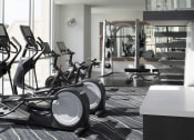 Thumbnail 13 of 44 - a room with a lot of exercise equipment and a chandelier