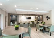 Thumbnail 17 of 31 - a communal area with tables and chairs and a kitchen and television