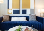 Thumbnail 15 of 47 - a living room with a blue couch and paintings on the wall