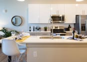 Thumbnail 13 of 47 - a kitchen with a sink and a counter top and a stainless steel refrigerator