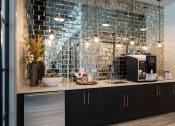 Thumbnail 32 of 47 - a kitchen with black cabinets and a counter with a sink and a microwave