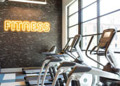 Thumbnail 33 of 47 - a gym with treadmills and weights in front of a window