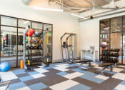 Thumbnail 34 of 47 - a gym with weights and other exercise equipment at the district at highland village apartments