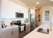 Thumbnail 2 of 47 - Pet-Friendly Apartments in Downtown Memphis, TN - The Landing - Kitchen with Hardwood Flooring, Stainless Steel Appliances, Quartz Countertops, and Flat-Panel Cabinetry.